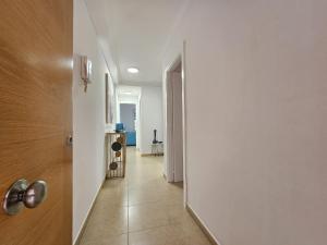 un pasillo con una pared blanca y una puerta blanca en Casa Cristina - Playa San Juan, en Playa de San Juan