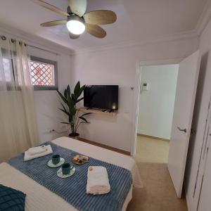 Una habitación con una mesa con un mantel azul y un televisor. en Casa Cristina - Playa San Juan, en Playa de San Juan