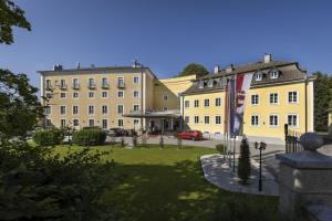 um grupo de edifícios com um gramado na frente em ARCOTEL Castellani Salzburg em Salzburgo