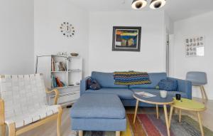 a living room with a blue couch and a table at Gudhjem Søpark Lejl 32 in Gudhjem