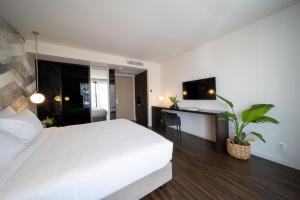 a bedroom with a large white bed and a desk at Azur Hotel in Athens