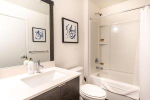 Un baño blanco con lavabo e inodoro. en Paid Garage Parking- King Bed-balcony Wd 55" Tv, en Tacoma 65 fotos más