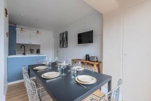 een eetkamer met een tafel met borden en wijnglazen bij Renovated 3-bedroom flat on the Grand Place in Lille