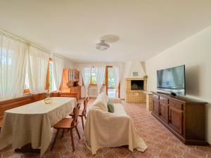 a living room with a couch and a table and a tv at Gio' Garden in Gabicce Mare