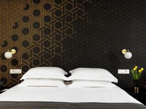 a bedroom with a bed and a black wall at Azur Hotel in Athens