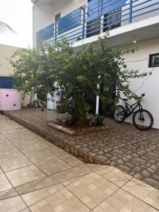 カンポ・グランデにあるHouse Dora AP 2 C AR CONDICIONADOの木々の立つ建物の隣に駐輪場 +2枚の写真
