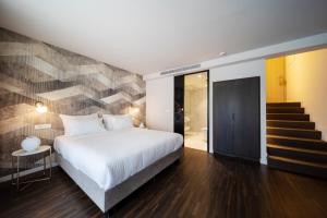 a bedroom with a large bed and a staircase at Azur Hotel in Athens