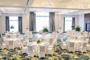 a ballroom with white tables and white chairs at Holiday Inn Detroit Northwest - Livonia by IHG in Livonia