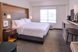 a hotel room with a bed and a table at Holiday Inn Detroit Northwest - Livonia by IHG in Livonia