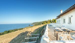 a house with a balcony with a view of the ocean at Zeruhaundi - baskeyrentals in Mendexa