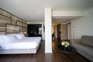 a bedroom with a large white bed and a couch at Azur Hotel in Athens