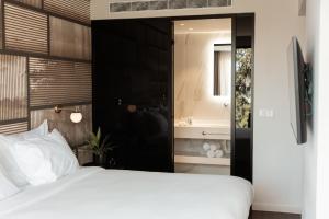 a bedroom with a bed and a sink and a mirror at Azur Hotel in Athens