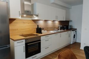 パッサウにあるCityHeart Appartement - Stadt Mitte - Stilvollの白いキャビネットと木製のカウンタートップを備えたキッチン +20枚の写真