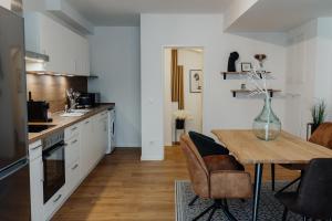 パッサウにあるCityHeart Appartement - Stadt Mitte - Stilvollの木製のテーブルとダイニングルームのあるキッチン
