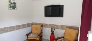 a room with two chairs and a tv on a wall at Departamentos El Trébol in Paso de los Libres