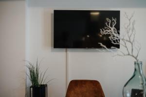 パッサウにあるCityHeart Appartement - Stadt Mitte - Stilvollの白い壁に掛けられた薄型テレビ
