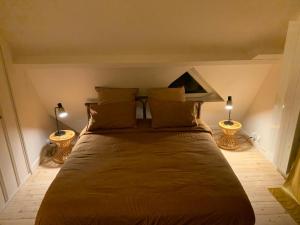 a bedroom with a large bed with two lamps at Chambre normande in Quittebeuf