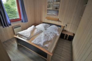 ein Bett mit weißen Laken und Kissen in einem Zimmer in der Unterkunft Wildgans 271 in Mirow