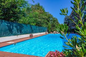 una piscina con acqua blu e alberi di MrBrown Aurelia Residence with Pool a Roma