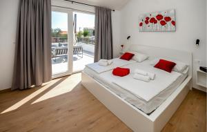 a bedroom with a large white bed with red pillows at Pet Friendly Home In Sibenik in Šibenik