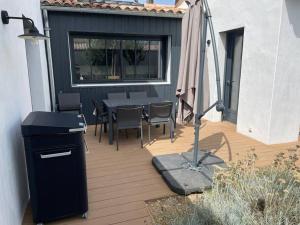 Un patio con una mesa y sillas y una ventana. en Villa - proche plages/commerces, en Le Bois-Plage-en-Ré 13 fotos más