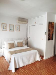 ein weißes Schlafzimmer mit einem großen weißen Bett. in der Unterkunft Acogedor estudio Algarrobo-Costa in Algarrobo-Costa + 14 Fotos