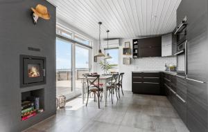 cocina con mesa, sillas y chimenea en Stunning Home In Rønde With Wifi, en Rønde