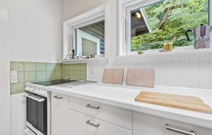una cucina con armadietti bianchi e una finestra di 3 Bedroom Nice Home In Liseleje a Liseleje