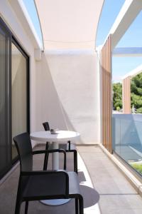 a table and chairs in a room with windows at Azur Hotel in Athens