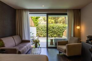 a hotel room with a couch and chairs and a patio at Azur Hotel in Athens