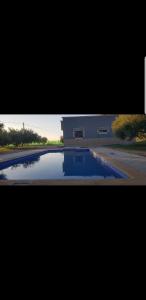 une piscine d'eau en face d'un bâtiment dans l'établissement Havre de paix, à Taourirt