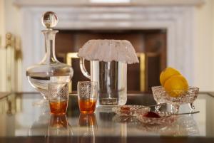 a table with glasses and a bottle and a drink at Archontiko Eleni Hotel in Andros
