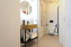 une salle de bain avec un lavabo et un miroir dans l'établissement Cà Bèla - Certosa SUITES, à Milan 56 autres photos