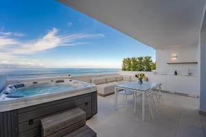 ein Whirlpool im Wohnzimmer mit Blick auf das Meer in der Unterkunft Aquasuites Luxury Penthouse A03 in Acantilado de los Gigantes