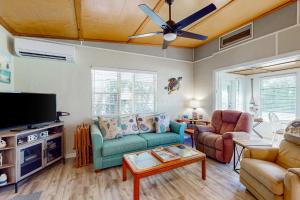 a living room with a couch and a ceiling fan at Sandy Feet Retreat in Englewood