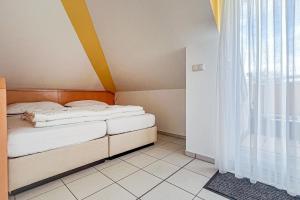 a small bedroom with two beds and a window at Villa Viktoria Whg 20 - "Ostseeloft" in Kölpinsee