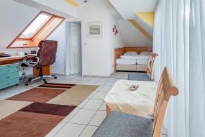 a room with a desk and a bed and a table at Villa Viktoria Whg 20 - "Ostseeloft" in Kölpinsee