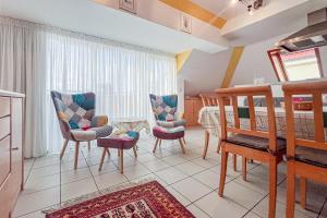 a living room with two chairs and a crib at Villa Viktoria Whg 20 - "Ostseeloft" in Kölpinsee