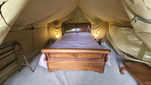 a bed in a tent with two lights on it at Roseland Valley Retreat in Tregoney