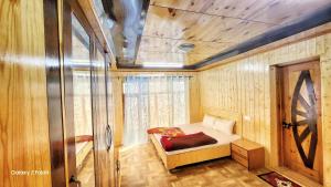 a bedroom with a bed in a room with wooden walls at Muskan Villa in Leh