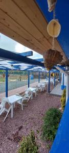a group of white tables and chairs under a blue roof at Pensiunea Blue House in Vadu