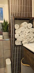 une pile de serviettes laminées sur une étagère dans une salle de bains dans l'établissement Nice apartment in Barnes, à Londres