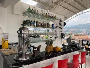 a bar with red chairs and a counter with drinks at Hotel Alameda Plaza in Cali
