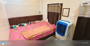 a bedroom with a pink bed and a fan at Family Room Bed Size 8x6 in Ujjain