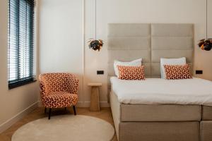 ブレダにあるBoutique hotel van Hamのベッドと椅子と窓のある寝室