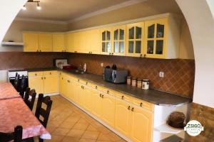 a kitchen with yellow cabinets and a counter top at Zsigó Tanya in Kiskunfélegyháza