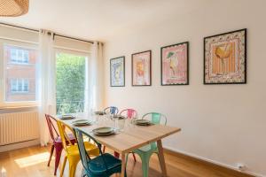 a dining room with a wooden table and chairs at Appartement 3 chambres, centre-ville avec parking in Tourcoing