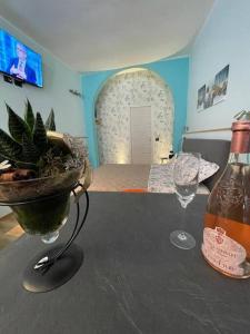 a table with a bottle of wine and two glasses at Perugia Home Apartment I Mille in Perugia +3 photos
