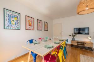 a dining room with a table and colorful chairs at Appartement 3 chambres, centre-ville avec parking in Tourcoing