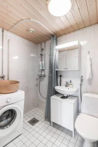 een badkamer met een wasmachine en een wastafel bij Cosy flat with good transport connections and Free parking in Vantaa